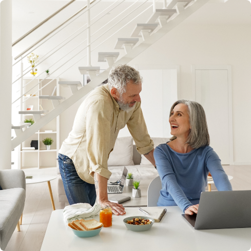 Women with a laptop men standing beside her and smiling